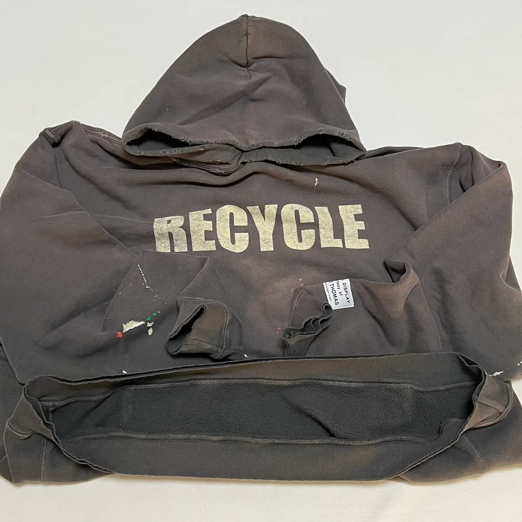 GALLERY DEPT. 90'S RECYCLE HOODIE WASHED BLACK 90'S washed hoodie with distressed eco-friendly slogans. Washed black S-XL. Ready-made garments are washed and dyed again. Multiple spots throughout the body are spray-faded. The ribs are cut and worn.